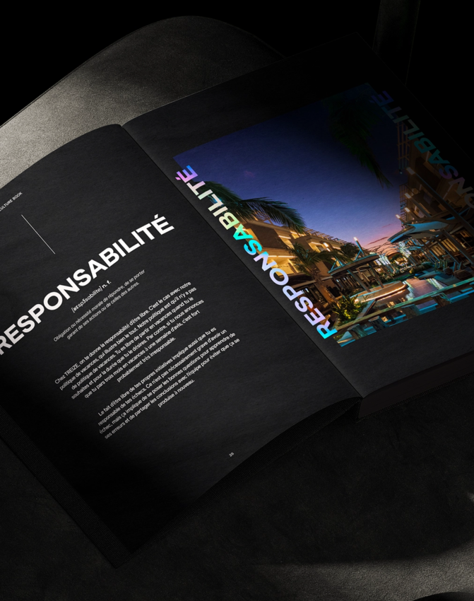 Un magazine ouvert sur une chaise sombre et rembourrée affiche une page avec le titre RESPONSABILITÉ en caractères gras et blancs et une photo colorée d'une scène en plein air sur la page opposée.