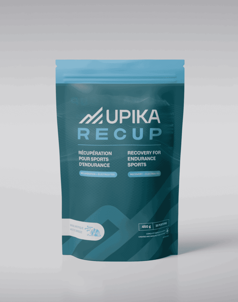 Un sachet sarcelle étiqueté Upika Recup avec un texte en français et en anglais pour la récupération de l'endurance sportive. L'emballage présente un graphique de montagne et comporte un poids de 450 g et des informations sur les 31 portions au bas de l'emballage.